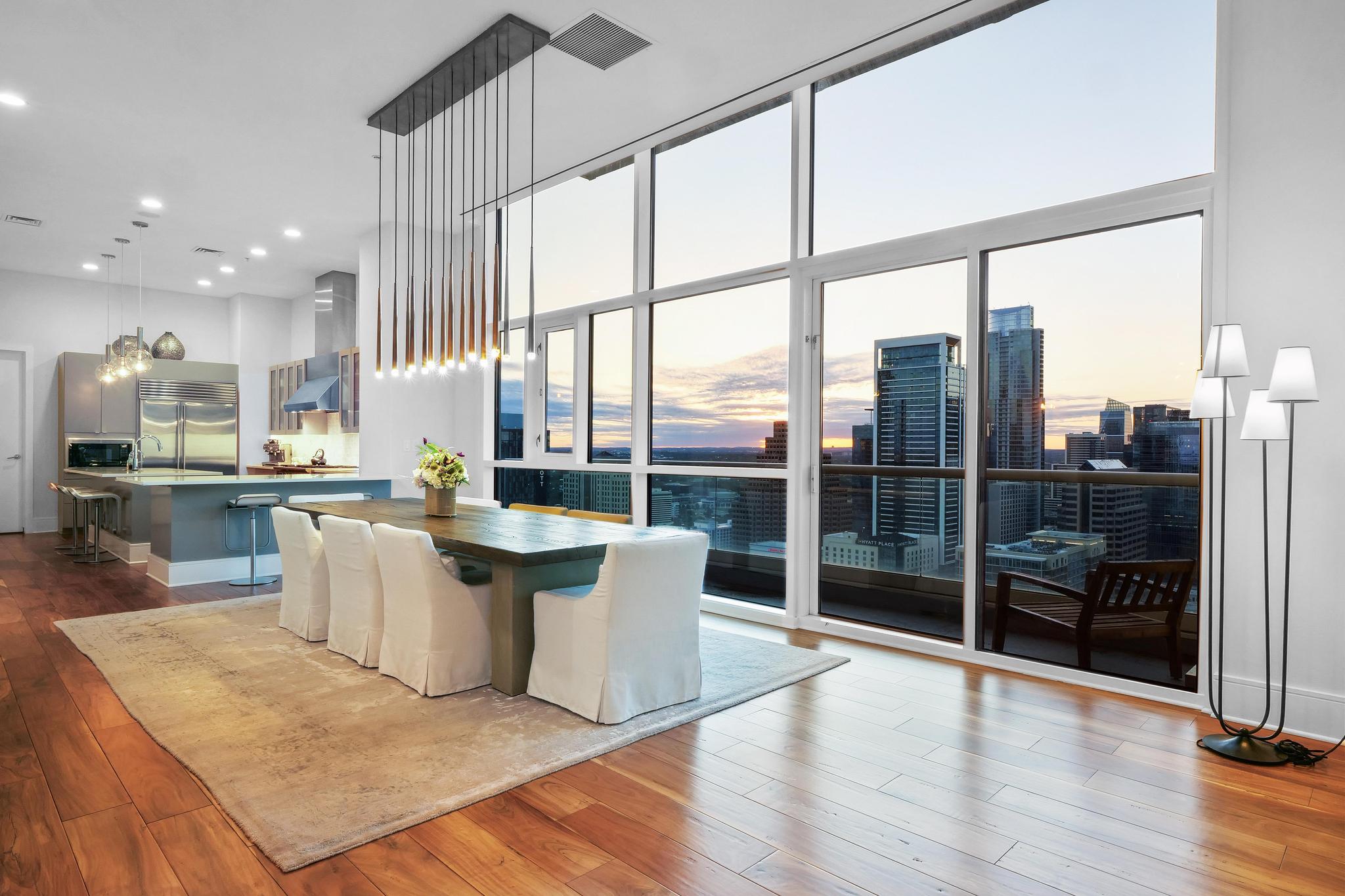 555 East 5th Street, Unit 3022 Austin, TX 78701 - Photo 5 of 40 Dining area featuring dark wood finished floors, a city view, expansive windows, recessed lighting, and a towering ceiling