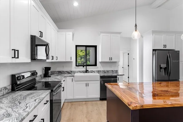 a kitchen with a sink stove top oven and refrigerator