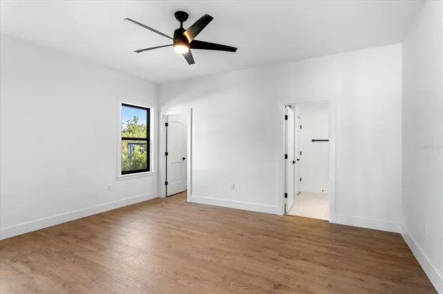 an empty room with fan and windows