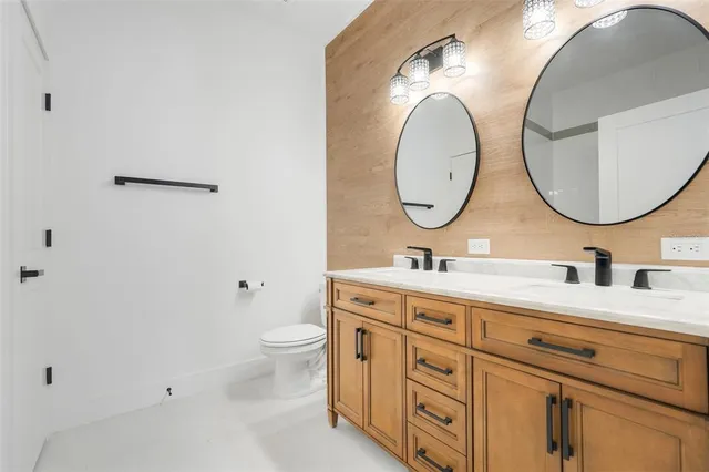 a bathroom with a granite countertop toilet a sink and a mirror