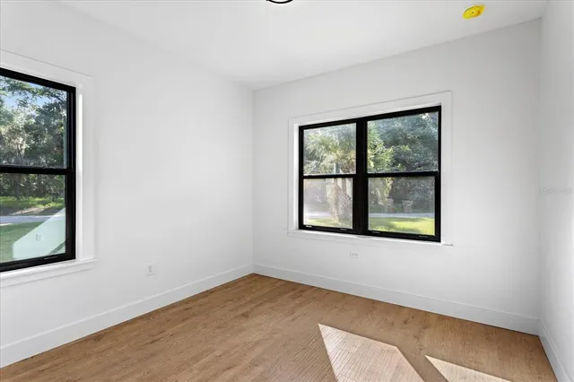 a view of a room with wooden floor and window