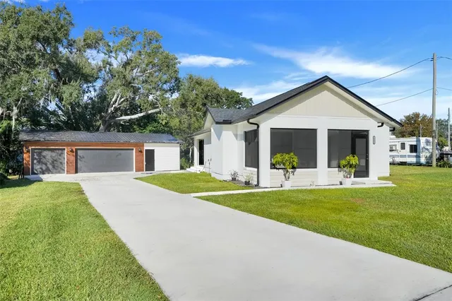 a view of a house with a patio and a yard