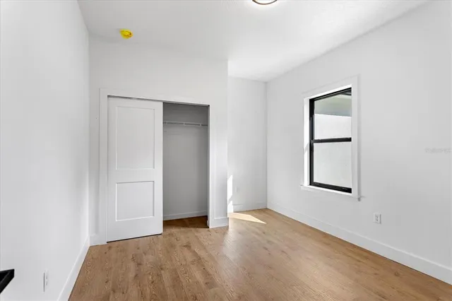 an empty room with windows and closet