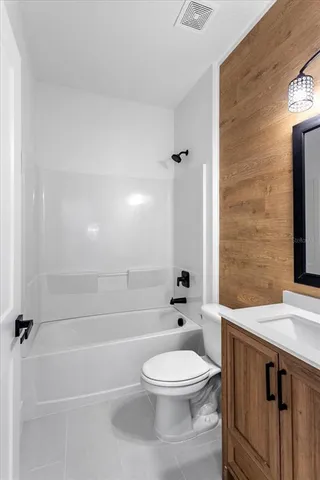 a bathroom with a bathtub shower sink mirror and toilet