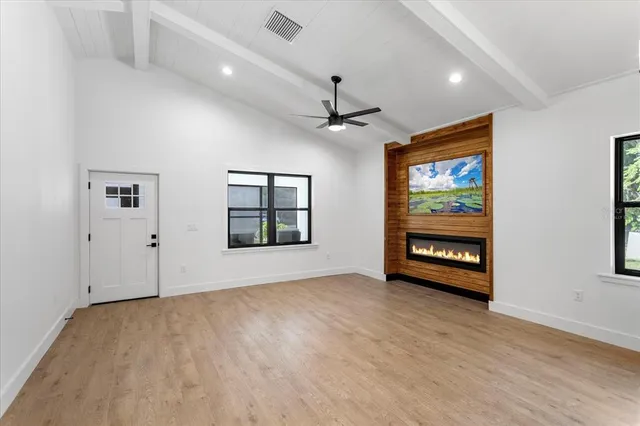 an empty room with windows and ceiling fan