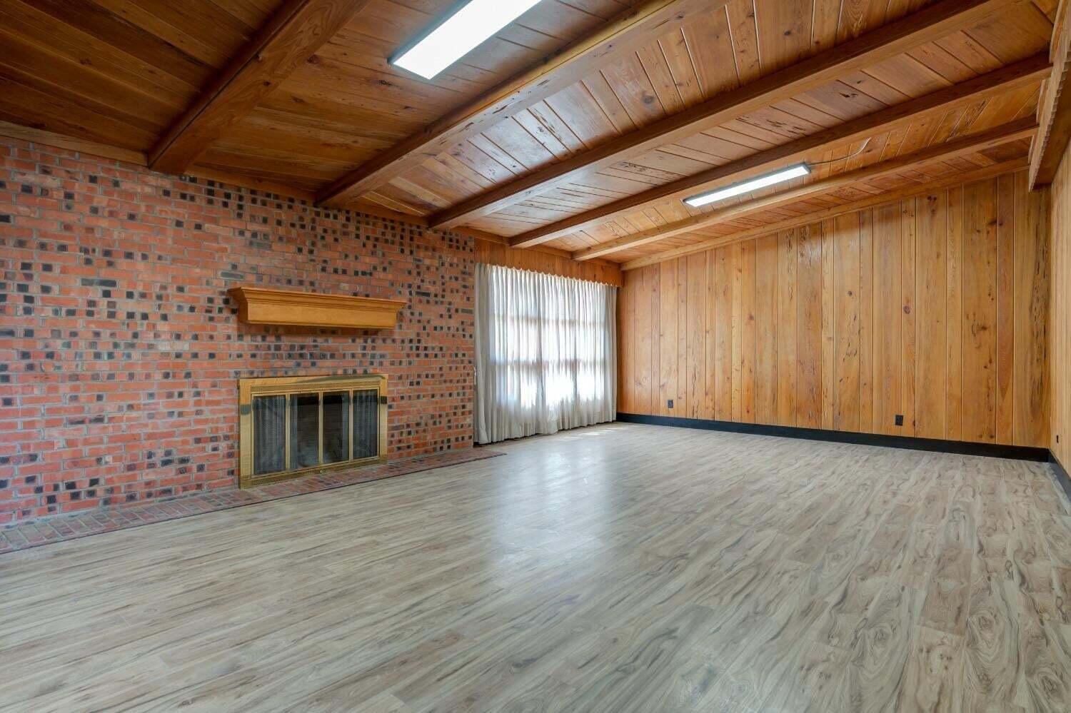 3410 40th Street Lubbock, TX 79413 - Photo 4 of 29 a view of an empty room with wooden floor and a fireplace