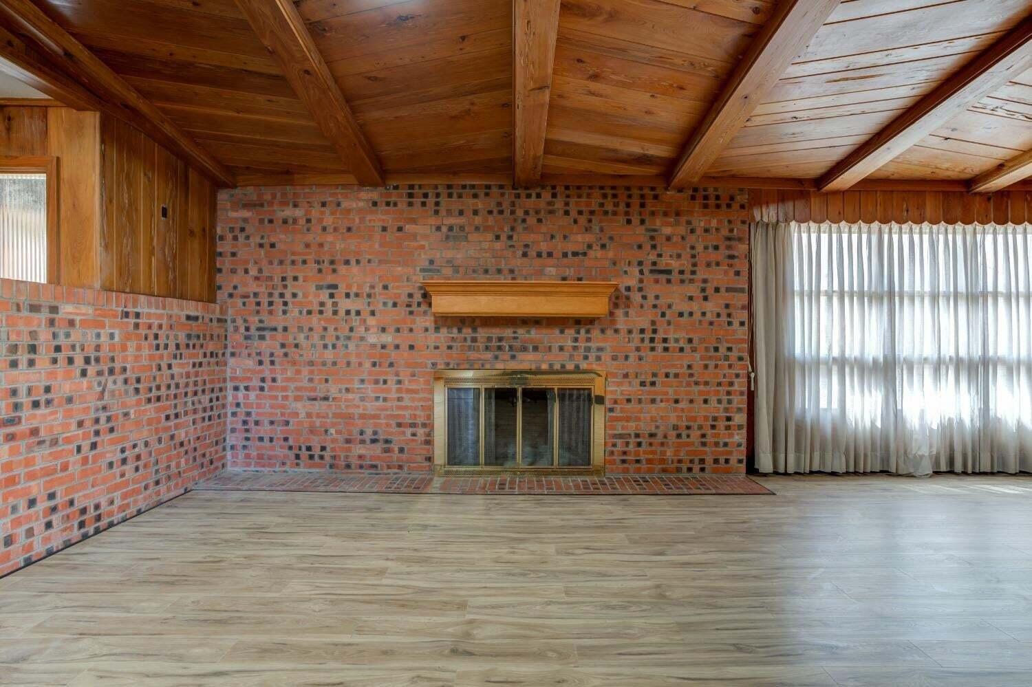 3410 40th Street Lubbock, TX 79413 - Photo 5 of 29 a view of an empty room with wooden floor and a fireplace