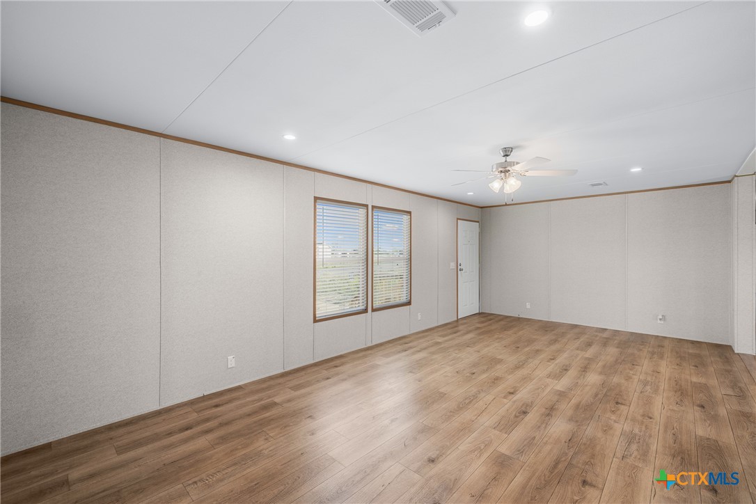 139 Azalea Ct Dale Dale, TX 78616 - Photo 14 of 26 a view of an empty room with wooden floor and a window