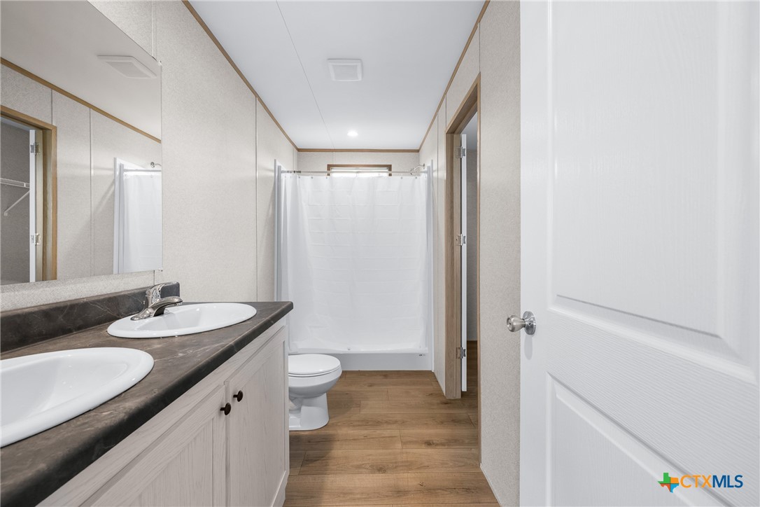 139 Azalea Ct Dale Dale, TX 78616 - Photo 21 of 26 a bathroom with a double vanity sink toilet and shower