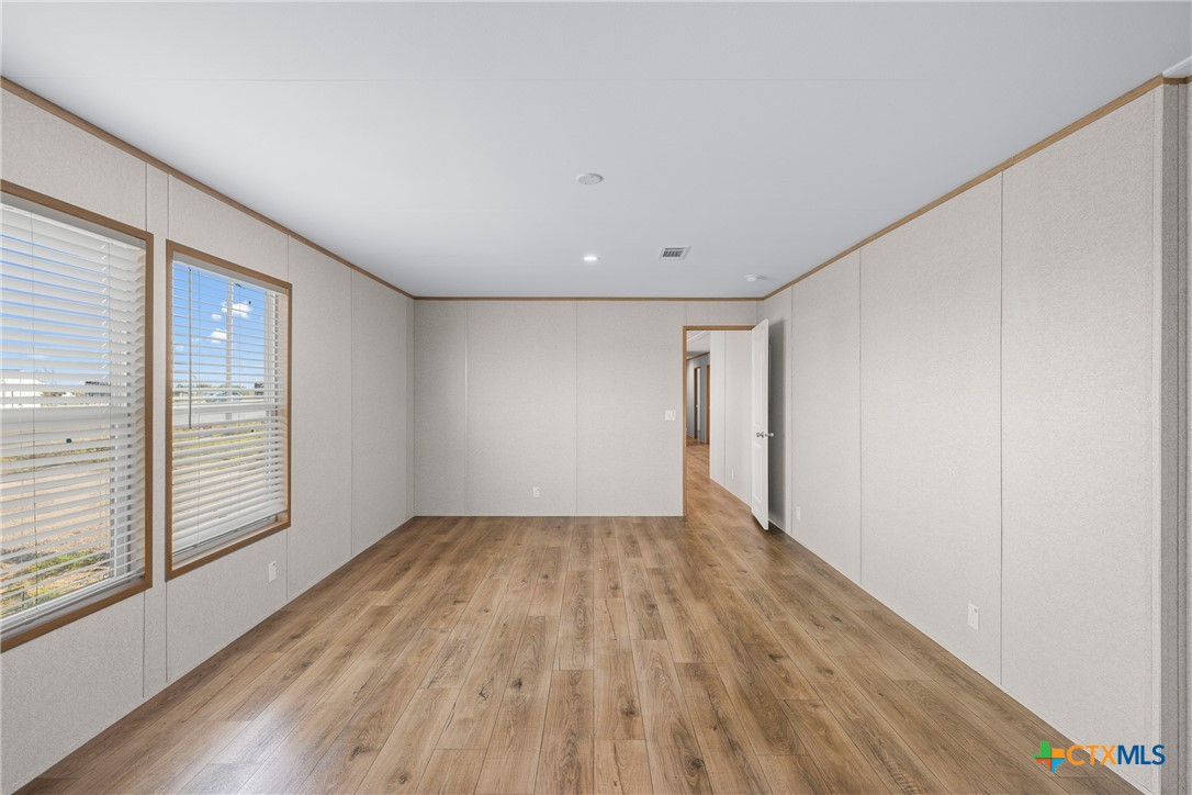 139 Azalea Ct Dale Dale, TX 78616 - Photo 22 of 26 a view of an empty room with wooden floor and a window