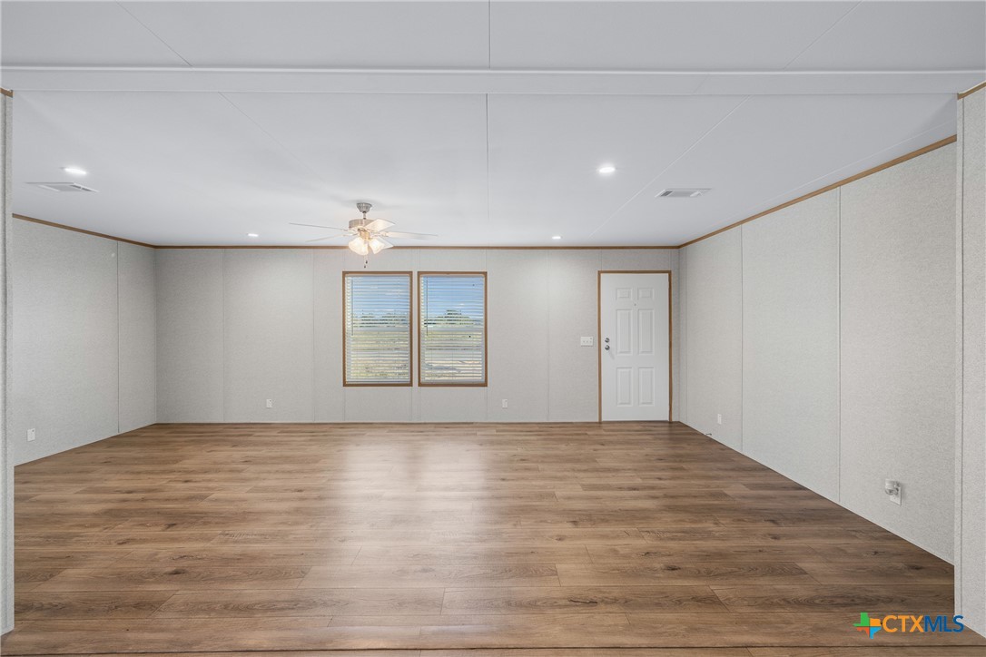 139 Azalea Ct Dale Dale, TX 78616 - Photo 25 of 26 a view of an empty room with window and wooden floor