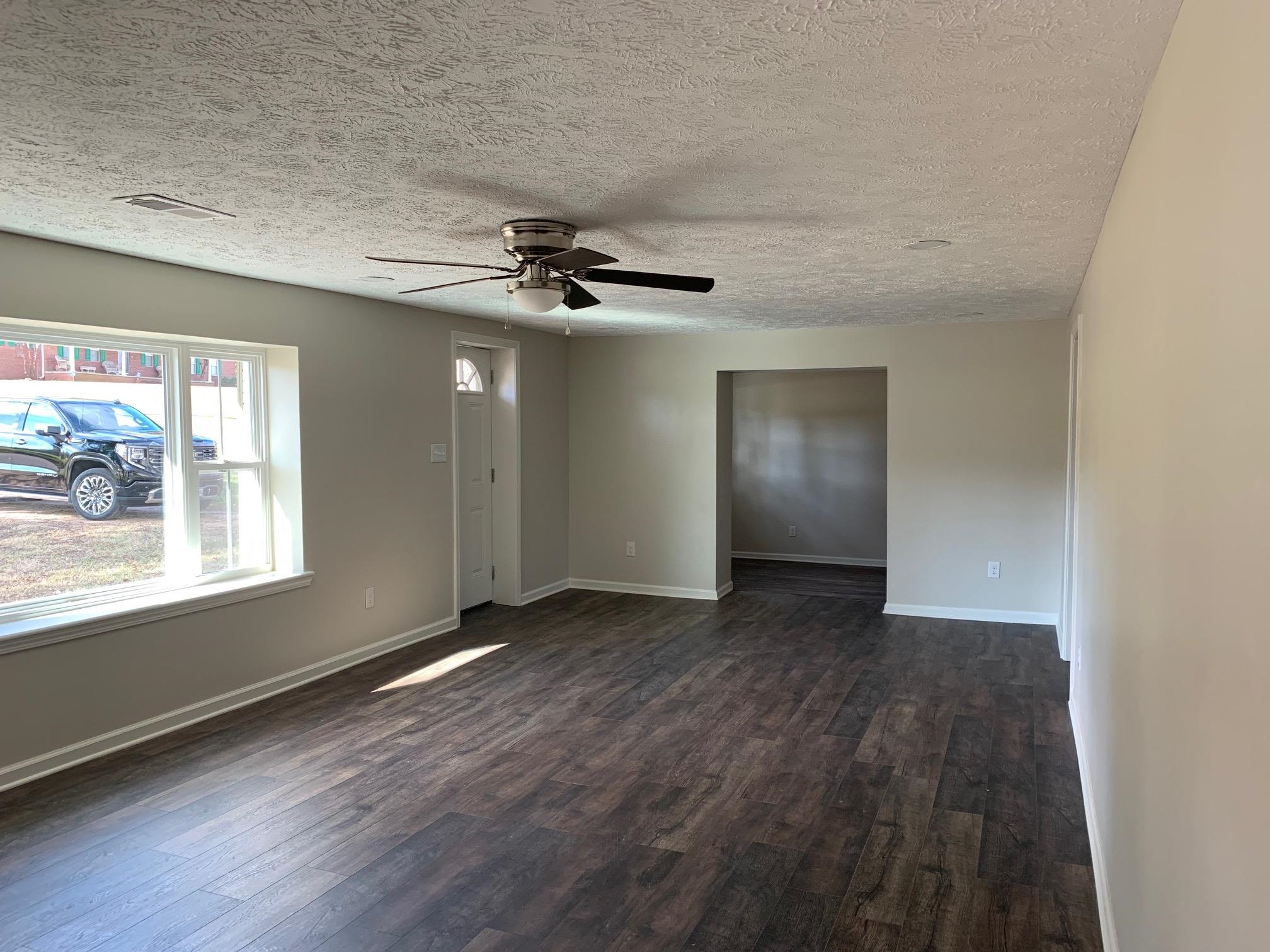 1612 Old Brownsville Road Ripley, TN 38063 - Photo 6 of 13 Empty room featuring a textured ceiling, dark hardwood / wood-style flooring, and ceiling fan