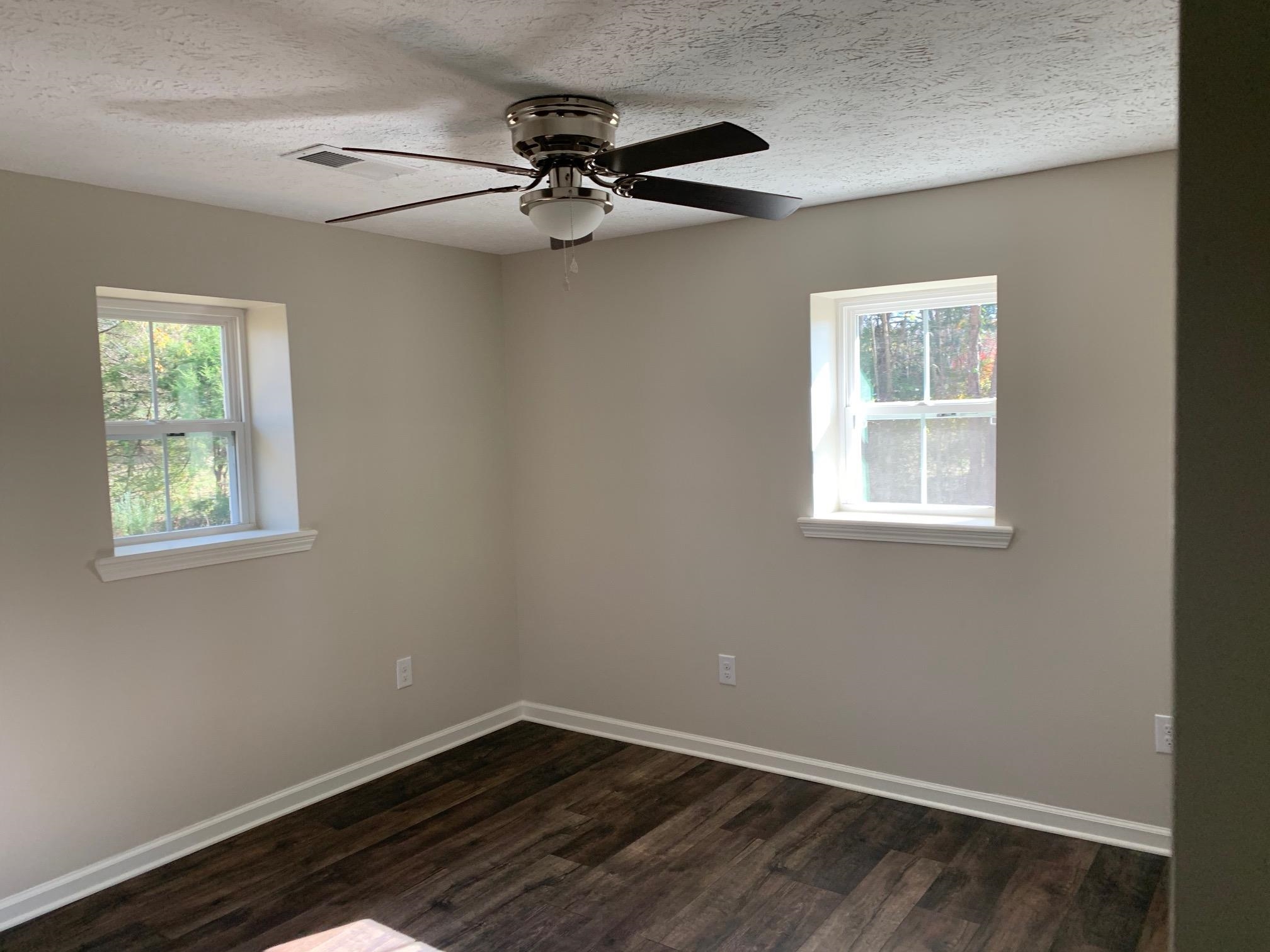 1612 Old Brownsville Road Ripley, TN 38063 - Photo 8 of 13 Unfurnished room featuring a textured ceiling, ceiling fan, and dark hardwood / wood-style floors