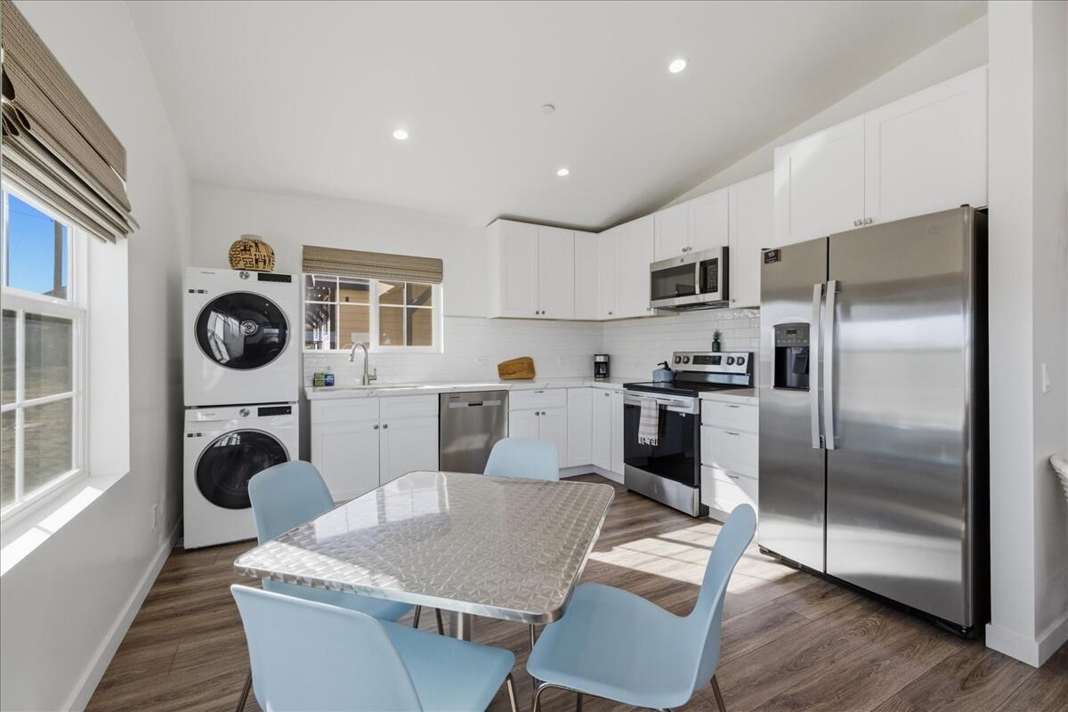 4884 Avenida Del Sol Joshua Tree, CA 92252 - Photo 17 of 66 a kitchen with stainless steel appliances granite countertop a refrigerator a stove a sink dishwasher and white cabinets with wooden floor