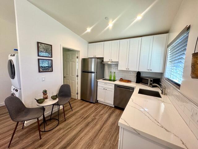 4884 Avenida Del Sol Joshua Tree, CA 92252 - Photo 41 of 66 a kitchen with a refrigerator a stove top oven a sink dishwasher and white cabinets with wooden floor