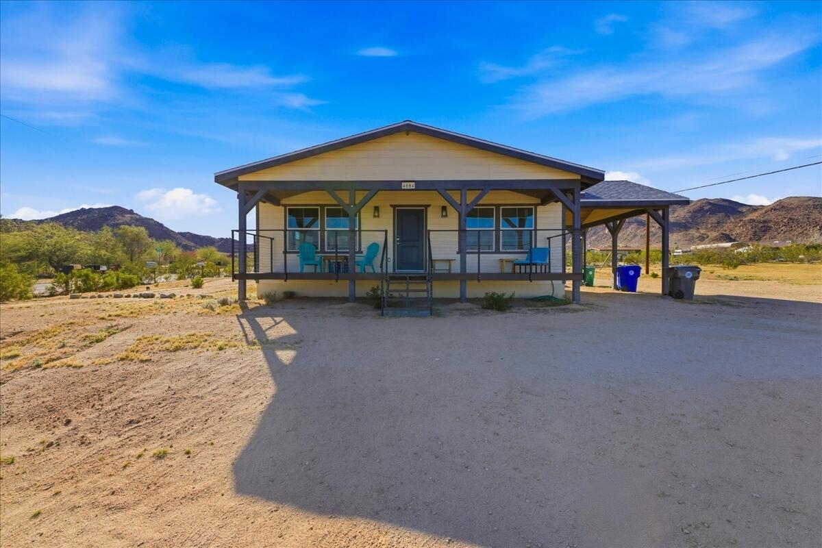 4884 Avenida Del Sol Joshua Tree, CA 92252 - Photo 52 of 66 a front view of a house with a yard