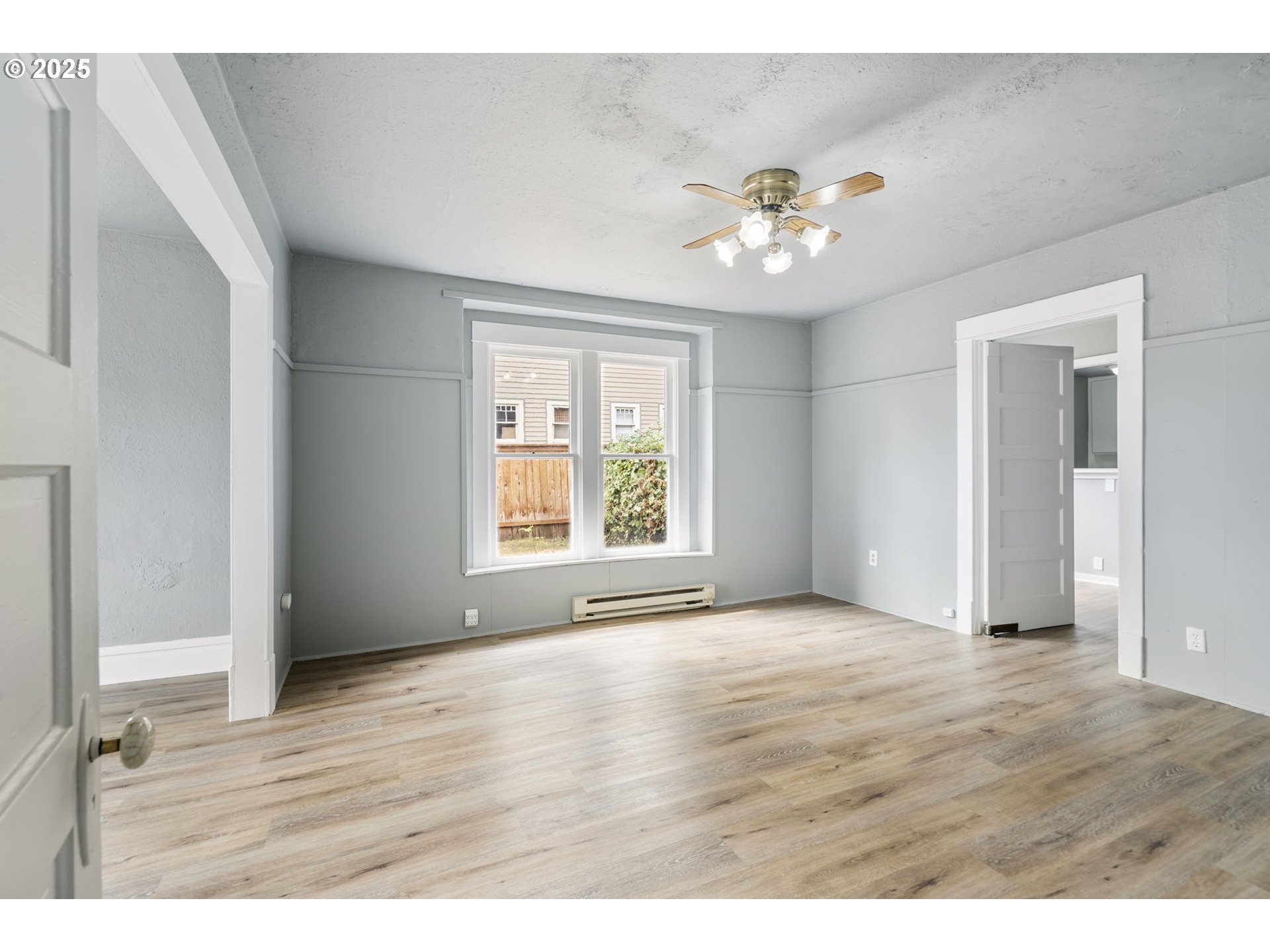 2035 4th Street Northeast Salem, OR 97301 - Photo 7 of 45 a view of an empty room with a window and wooden floor