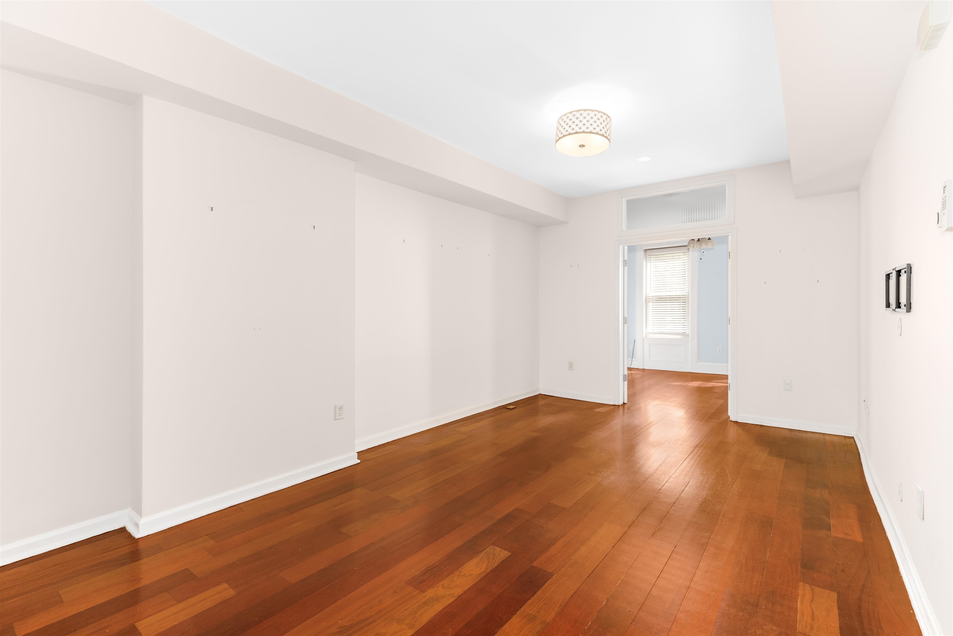 228 Jefferson Street, Unit 2 (R) Hoboken, NJ 07030 - Photo 2 of 15 a view of an empty room with wooden floor and a window