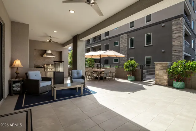 a view of a patio with table and chairs under an umbrella