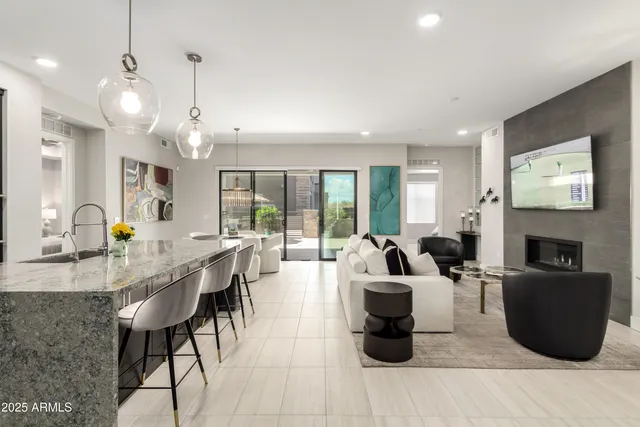 a living room with fireplace furniture and a large window