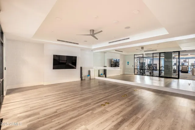 a view of a livingroom with wooden floor and a kitchen space