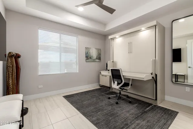 a view of a workspace with furniture and a window