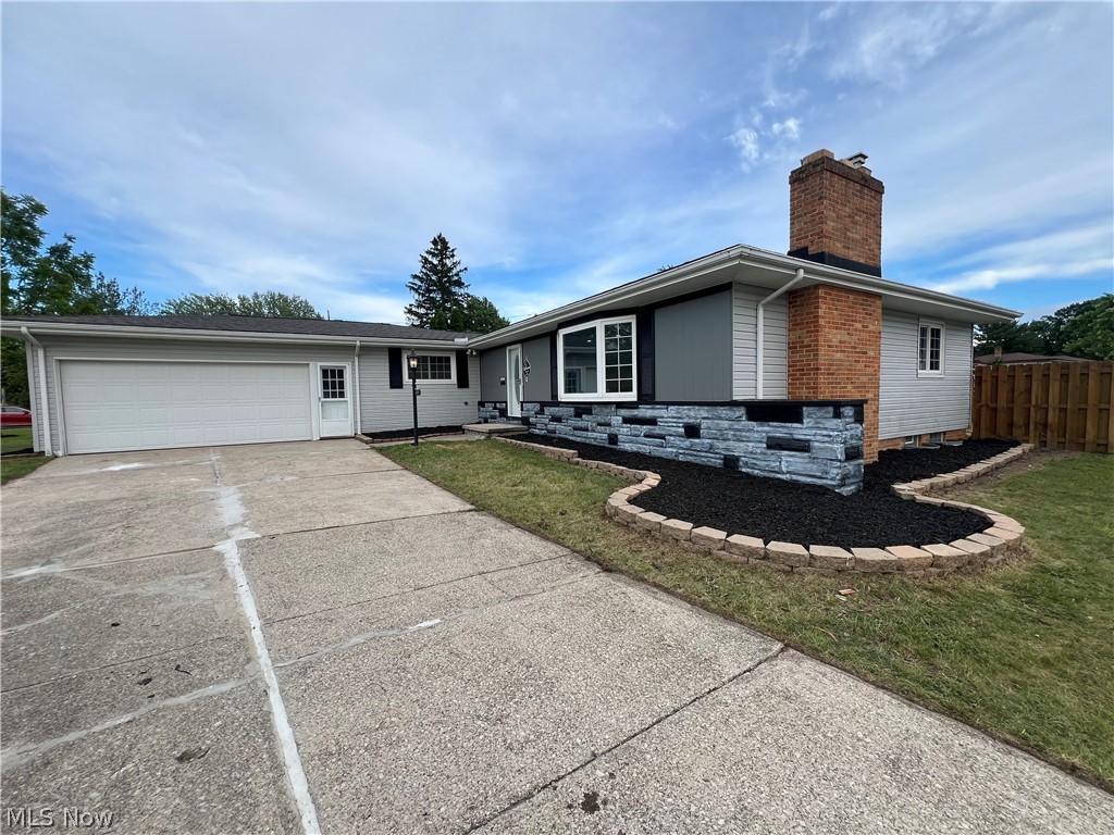 Single story home with a garage and a front yard