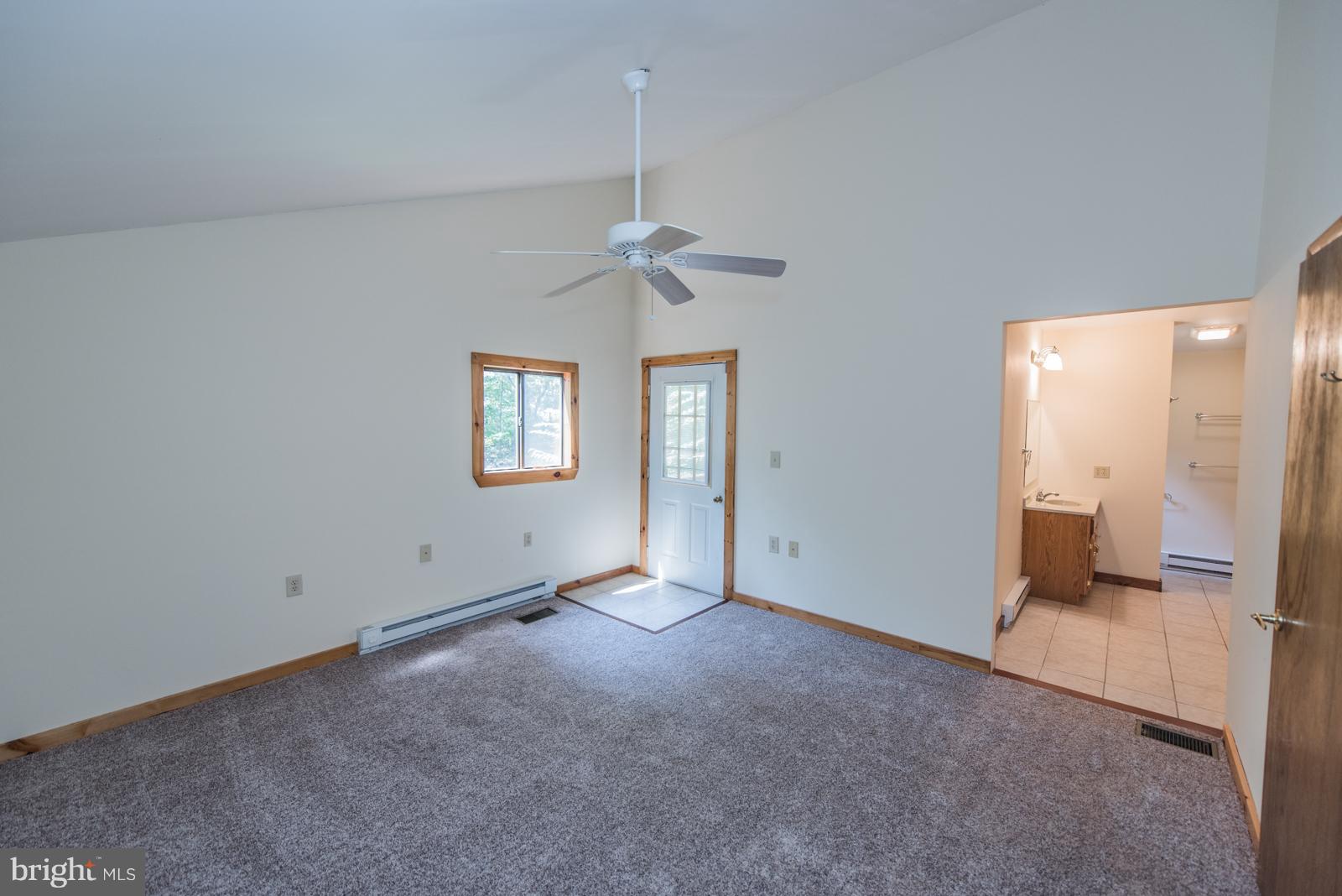 116 Hickory Hollow Road Berkeley Springs, WV 25411 - Photo 13 of 30 an empty room with windows and ceiling fan