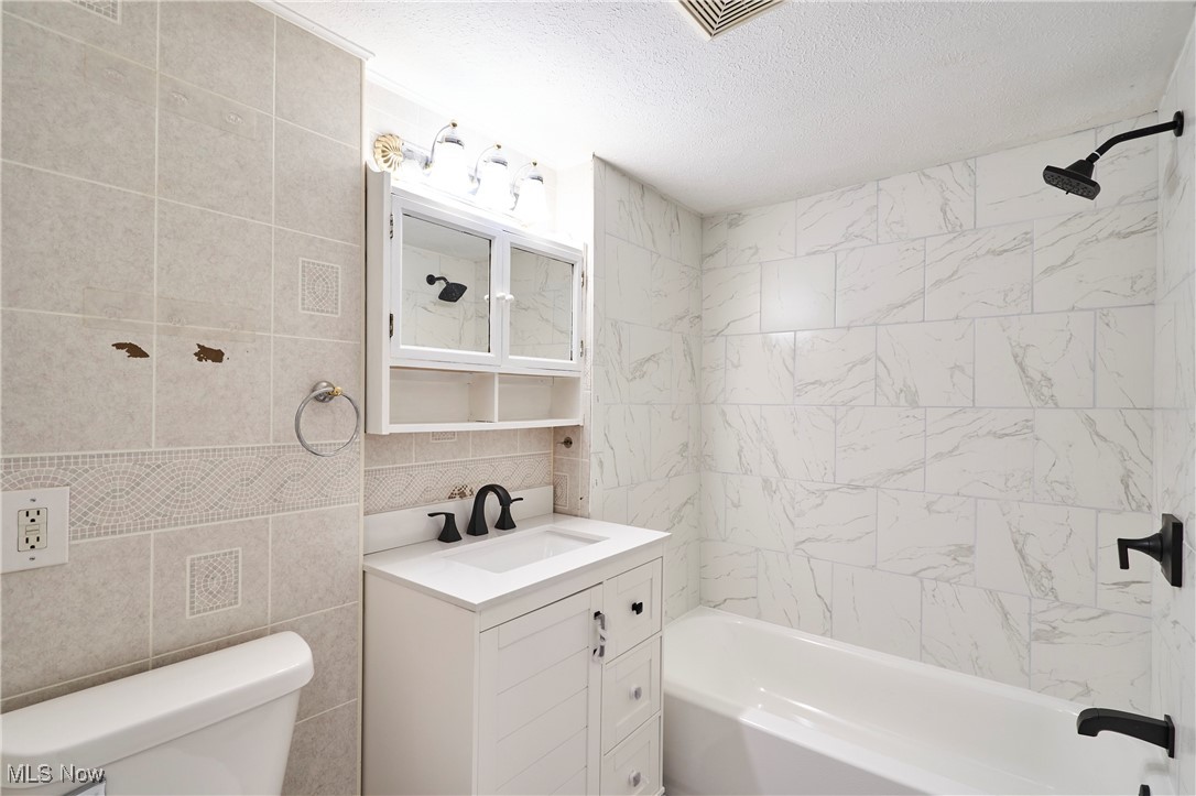 1001 Dayton Street Akron, OH 44310 - Photo 16 of 27 New Bathroom featuring shower / bath combination, tile walls, vanity, new faucets and lighting
