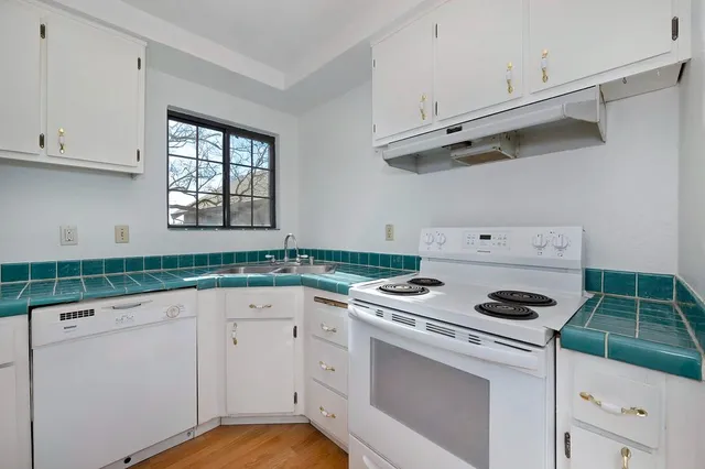 a kitchen with white cabinets appliances and a sink