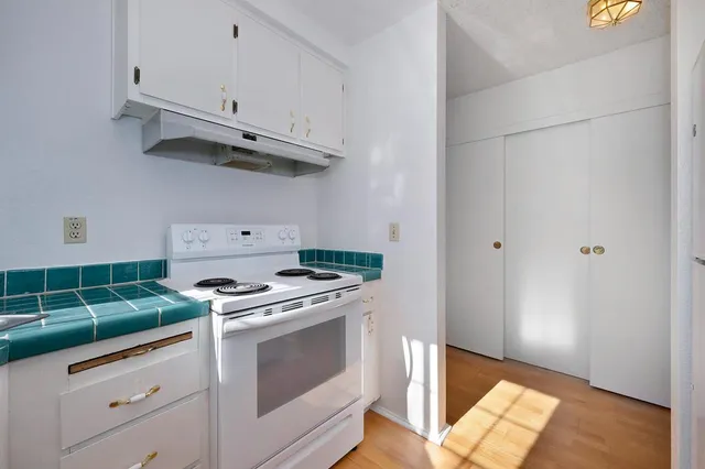 a kitchen with white cabinets and a stove