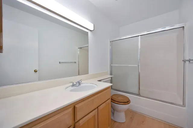 a bathroom with a granite countertop sink a toilet and shower