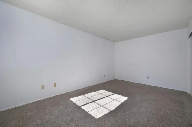an empty room with white wall and a window