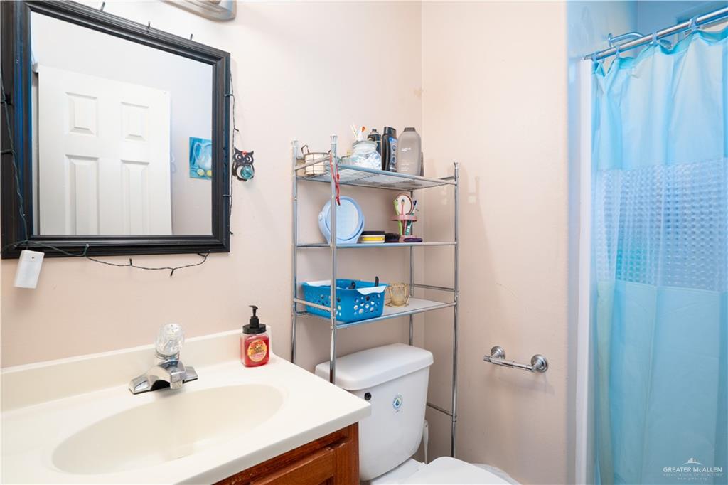 24609 Ocean Street Monte Alto, TX 78538 - Photo 13 of 31 a bathroom with a sink a toilet and shower curtain