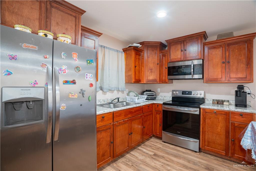 24609 Ocean Street Monte Alto, TX 78538 - Photo 5 of 31 a kitchen with stainless steel appliances granite countertop a refrigerator stove microwave and sink