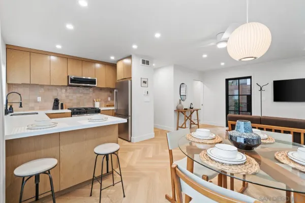a kitchen with stainless steel appliances granite countertop a sink a stove a kitchen island with chairs and cabinets