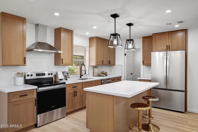 a large kitchen with stainless steel appliances lots of counter space and wooden floor