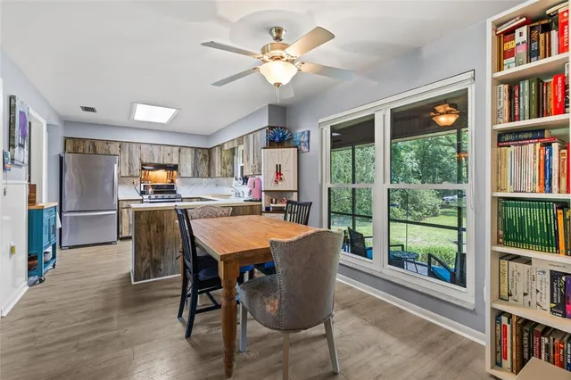 a dining room with furniture large window and wooden floor