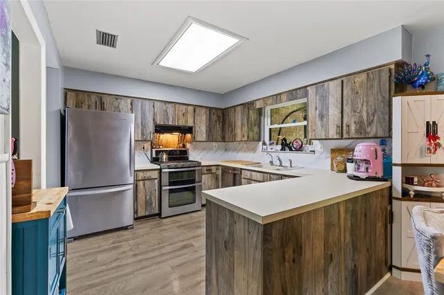 a kitchen with a refrigerator and a stove top oven