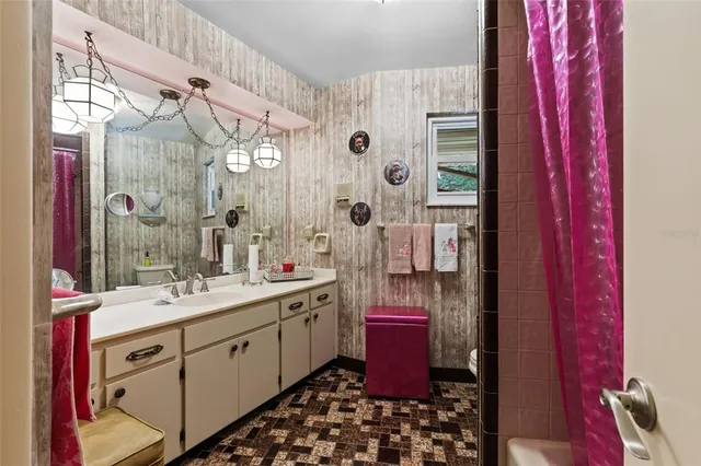 a bathroom with a sink a mirror a vanity and a shower