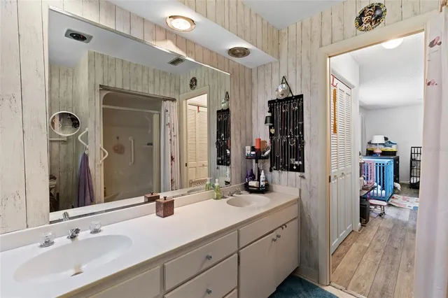 a bathroom with a double vanity sink a mirror and a shower