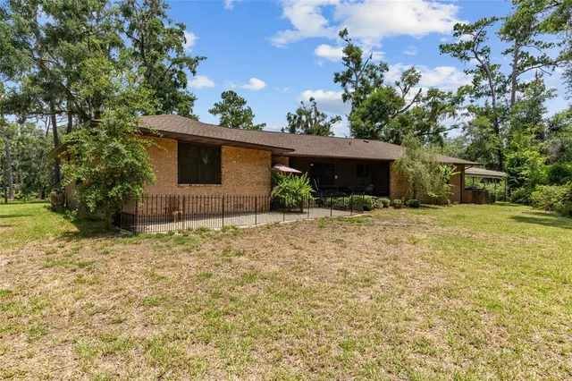 a view of a house with a yard and potted plants