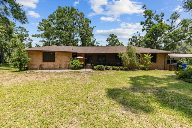 a front view of house with yard and trees in the background