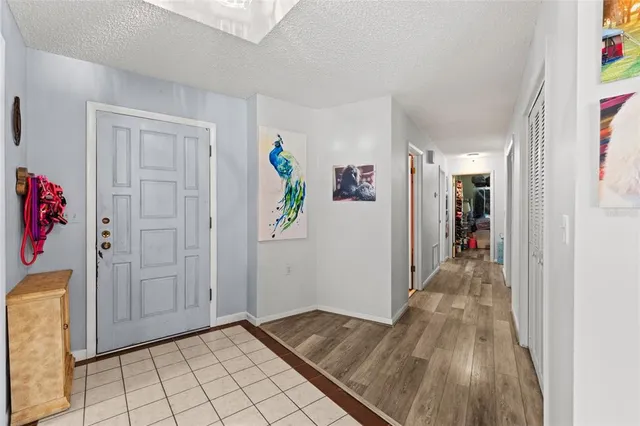 a view of a hallway view with wooden floor and refrigerator
