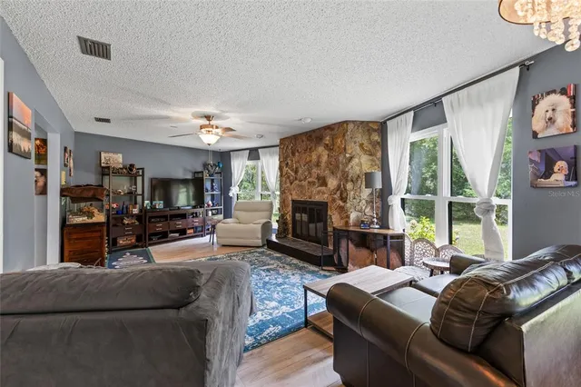 a living room with furniture a large window and a fireplace