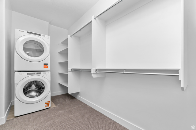 1352 West 2350 South, Unit 18 Perry, UT 84302 - Photo 15 of 26 Integrated laundry area featuring stacked appliances, built-in shelving, hanging rods, and carpet flooring