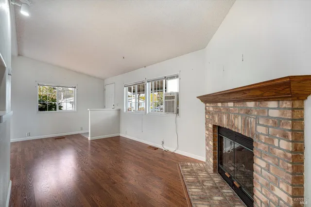 an empty room with windows and fireplace