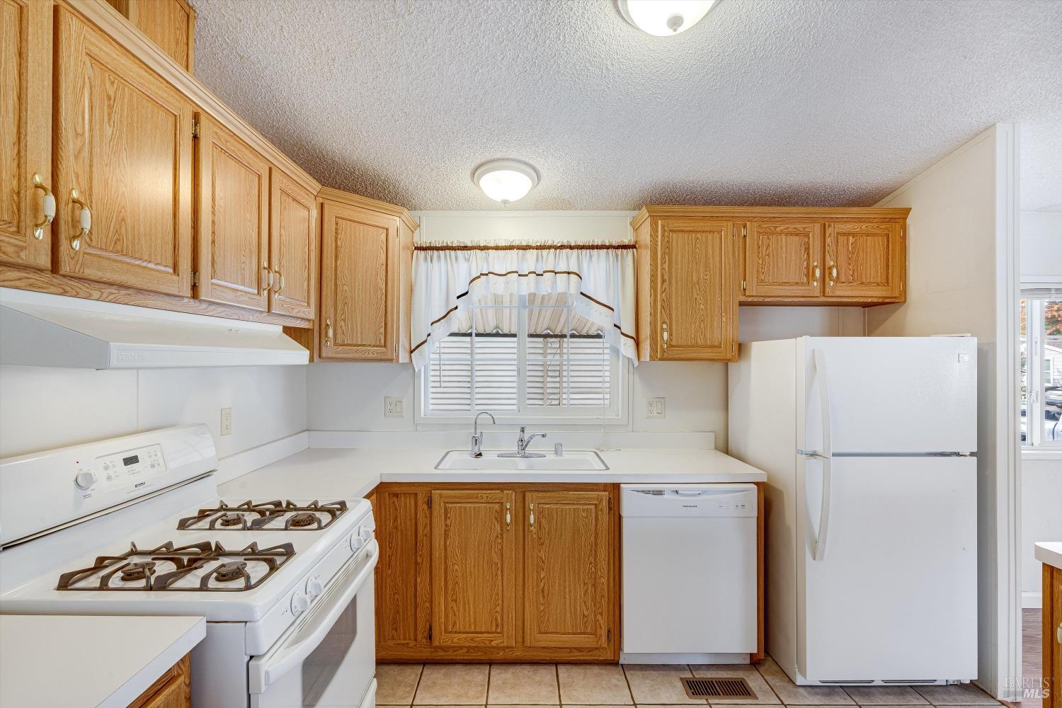 146 Westgate Circle Santa Rosa, CA 95401 - Photo 20 of 41 a kitchen with a stove a refrigerator and a sink