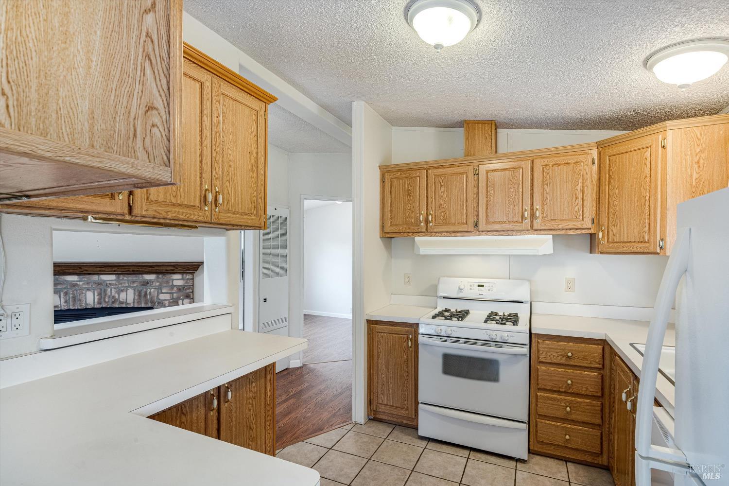 146 Westgate Circle Santa Rosa, CA 95401 - Photo 23 of 41 a kitchen with stainless steel appliances granite countertop a stove a microwave and a white cabinets