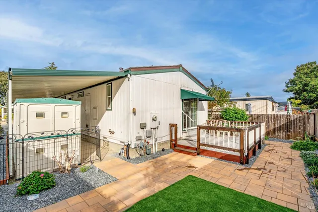 a view of a house with backyard and sitting area